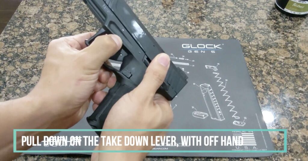 Pull down on the takedown lever with your off hand